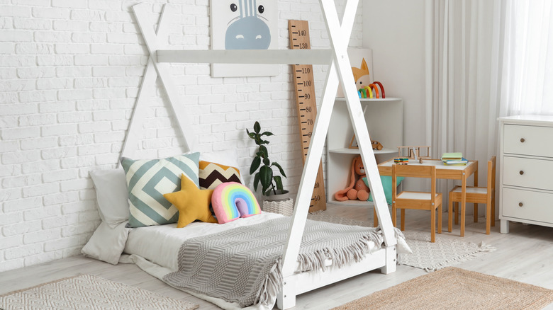 Gri battaniye ve çadır benzeri yatak çerçeveli zemin yatak