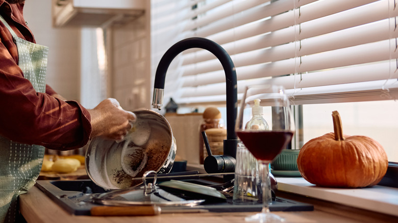 Önlük giyerken temizleyen bir adam