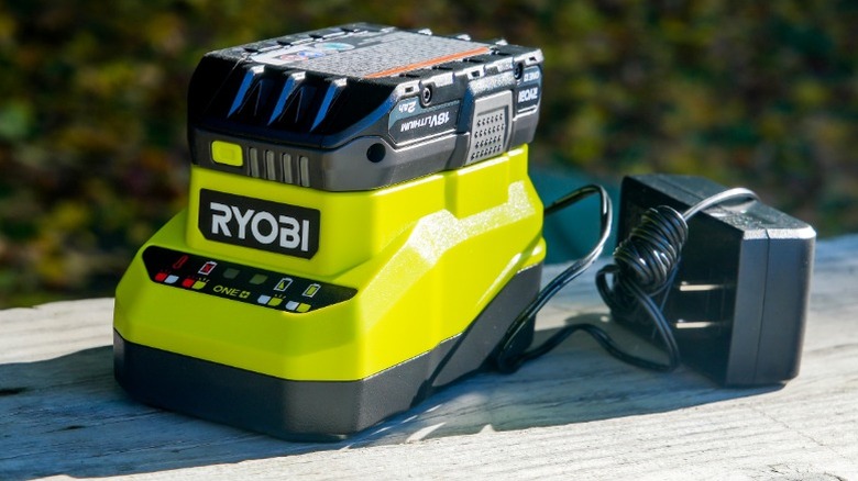Ryobi 18V Lityum İyon Pili Şarj Cihazında Ahşap Yüzeyinde Adaptörlü