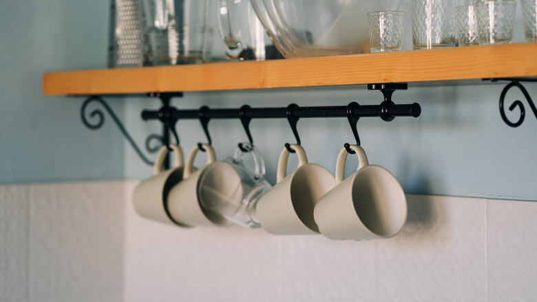 Kupalar, yüzen bir rafın altında kancalarla çubukta asılı