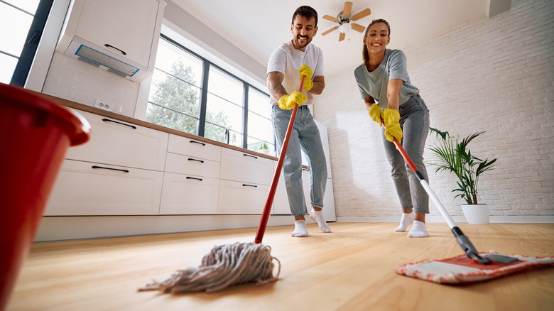 Gülümseyen Çift Moping Ahşap Zeminin Düşük Açılı Görünümü