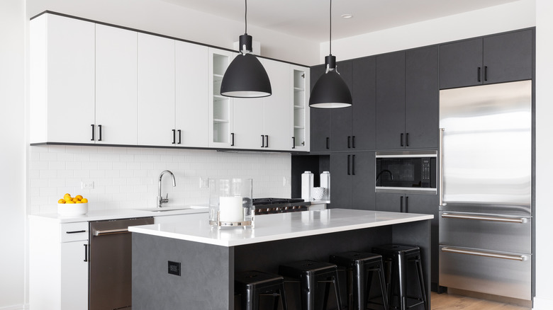 Siyah beyaz bir mutfak görev aydınlatması, vurgu aydınlatması ve havai aydınlatma kullanır