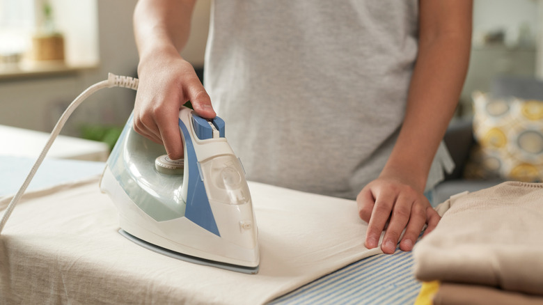 Bir bez peçeteyi ütüleyen bir kişi