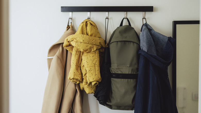 Duvara monte bir palto rafında asılı paltolar