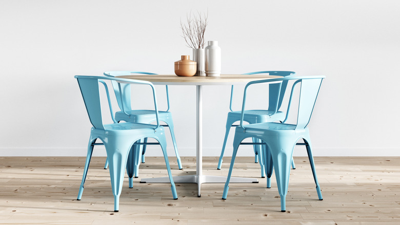 Boyalı metal sandalyelerle çevrili bir ofis masası