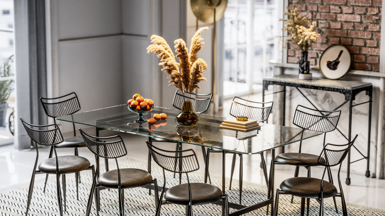 Şık boyalı metal sandalyelerle çalınan bir yemek odası masası