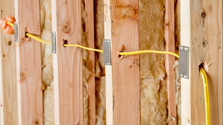 Duvar saplamalarından geçen ve çelik plakalarla korunan NM kablosu