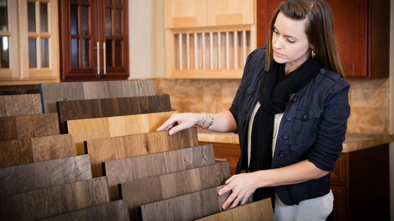 Bir mağazadaki döşeme seçeneklerine bakan kadın