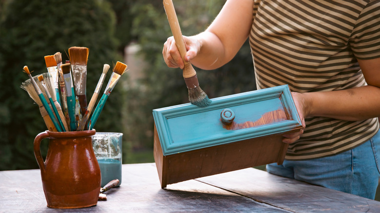 Bir çekmeceyi mavi boyama kişinin yakın çekilmesi