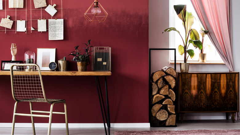 Koyu ahşap yan masa ve masalı Oxblood kırmızı oda