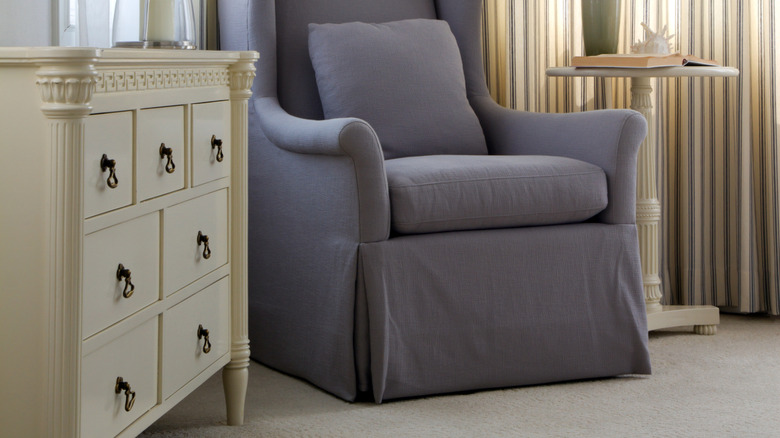 Beyaz şifoniyer ve masalı mor süpürülmüş sandalye