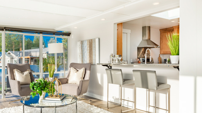 Mutfağın içine bir pencere geçiren temiz, parlak bir oturma odası.