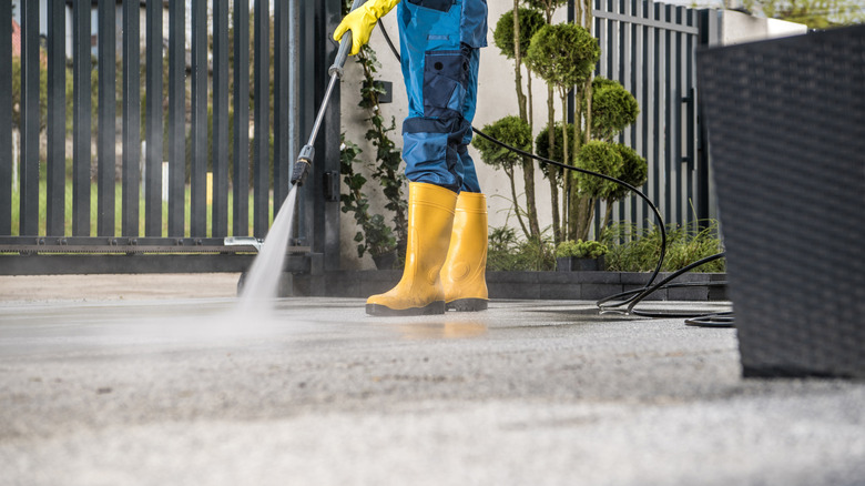 Birisi beton bir araba yolunu yıkıyor.