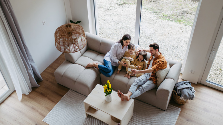 Minimalist bir evde oturma odasında oturan aile