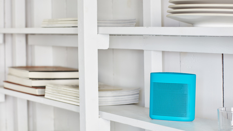 Mavi kablosuz hoparlörlü beyaz raflar