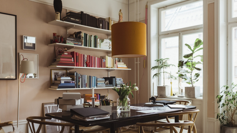 Raflarda kitap yığınları ile ofis