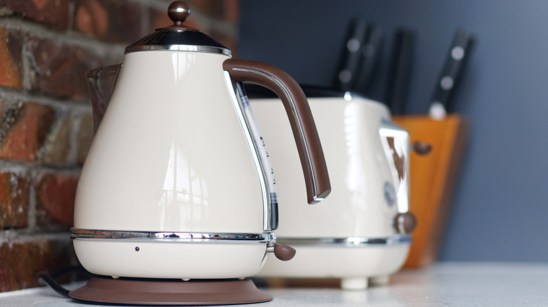 Beyaz ve kahverengi su ısıtıcısı ve eşleşen ekmek kızartma makinesi