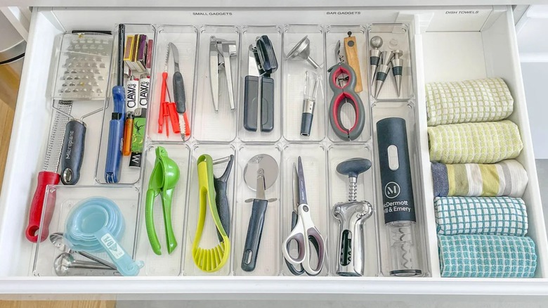 Depolama organizatöründe aletler ve mutfak havluları ile iyi organize mutfak adası çekmecesi