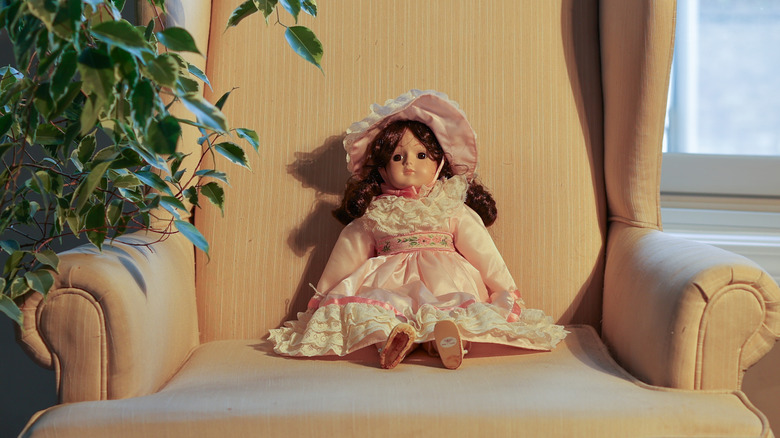 Bir sandalyede oturan vintage bisque bebek