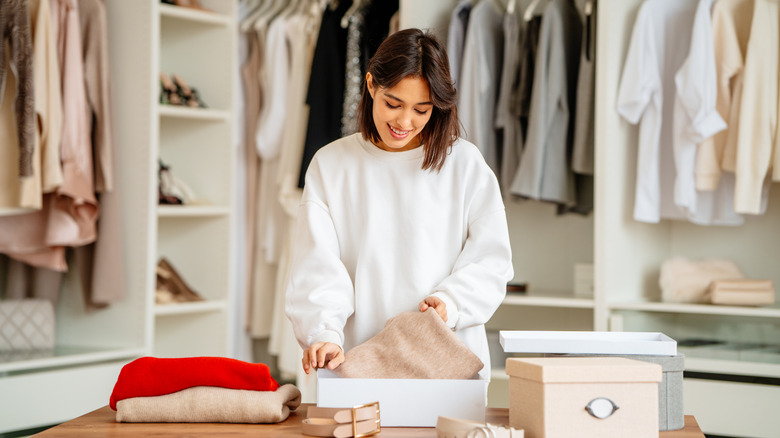 Yürüyüş dolap paketleme kıyafetleri içinde duran kadın