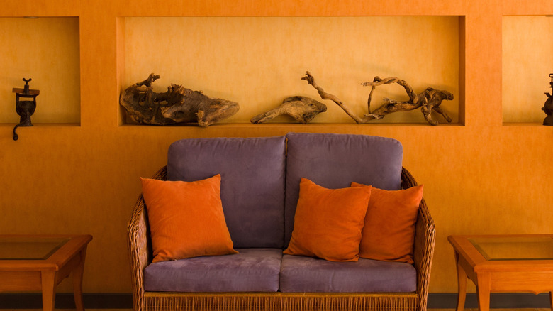 Mor kanepeli ve turuncu atış yastıkları ile turuncu oturma odası