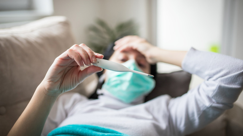 Yüz maskesi kontrol sıcaklığı olan kişi