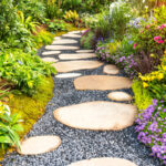 Gölgeli bir bahçe geçidini veya yolu güzelleştiren yoğun büyüyen zemin örtüsü