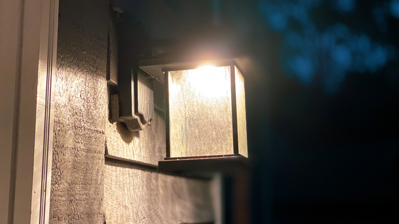 Ev dışında dikdörtgen, geometrik bir armatürde sıcak beyaz sundurma ışığı.