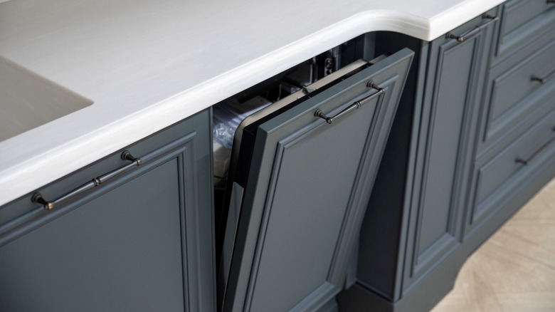 Donanma mavi dolaplarının arkasında yerleşik bir bulaşık makinesi gizlenmiştir