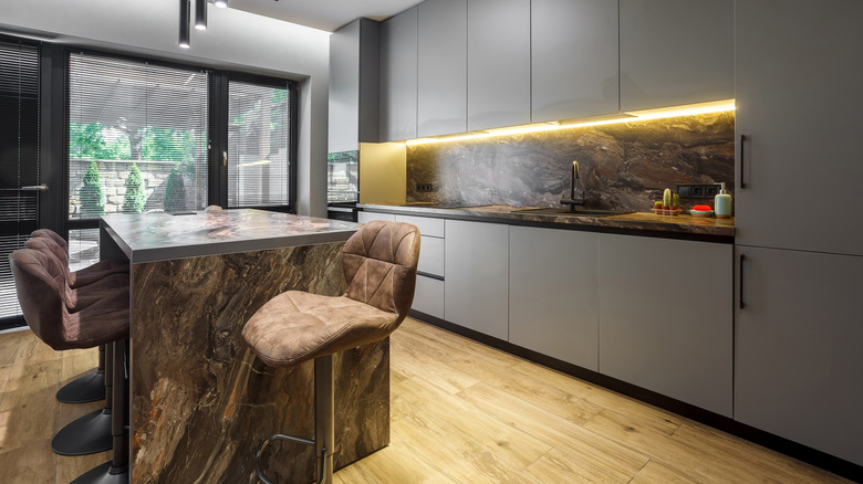 Şık gri bir mutfakta bir panel hazır buzdolabı yer alıyor