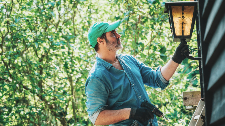 Evde dış ışık takan kişi