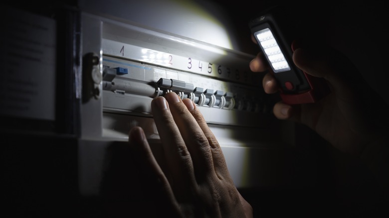 Bir kişi bir kesici kutusunun üzerine bir el feneri