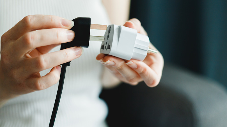 Adaptöre takma koyan kişi