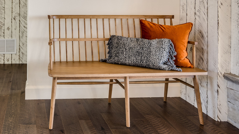 Koltuğa atma yastıkları olan ahşap bir giriş yolu tezgahı