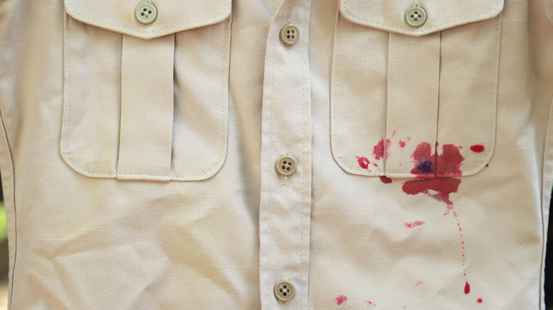 Düğmeli bir gömlek üzerine kırmızı şarap dökülmesinin yakın çekim görüntüsü