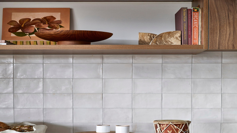 Taş parçalarının ve kasenin yanındaki rafta mutfakta yemek kitapları