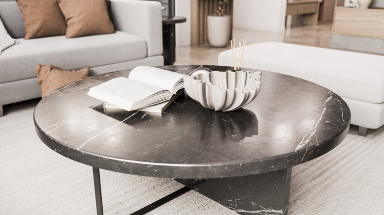 Oturma odasında taş sehpa üzerinde açık kitaplar