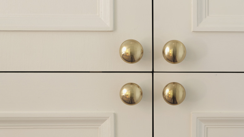 Beyaz dolap kapılarını dört cilalı pirinç dolap çeker