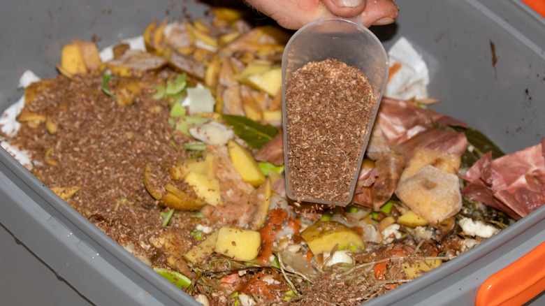 Bir kova kompostuna Bokashi kepeği ekleniyor.