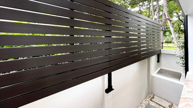 Beyaz duvarda siyah vinil çit panelleri