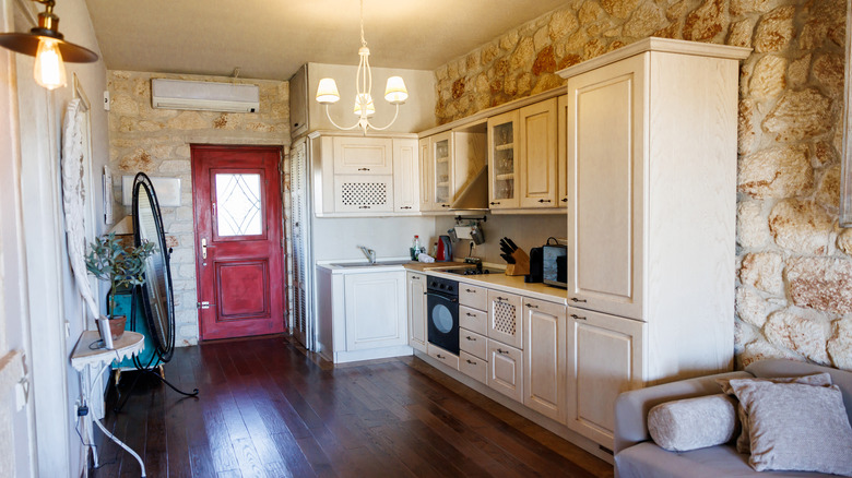 Taş duvarlı ve kırmızı ön kapılı küçük rustik mutfak