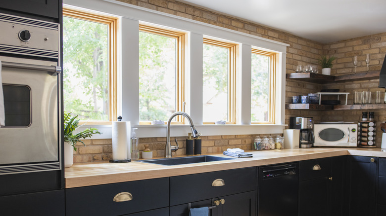 Tuğla backsplash ile özetlenmiş dört kare pencere
