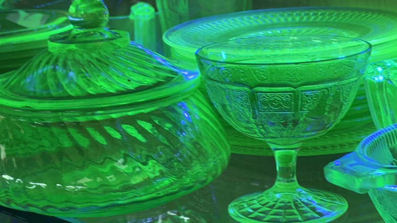 Bir antika dükkanı, siyah bir ışık altında parlayan birkaç depresyon dönemi uranyum camı sergiler.