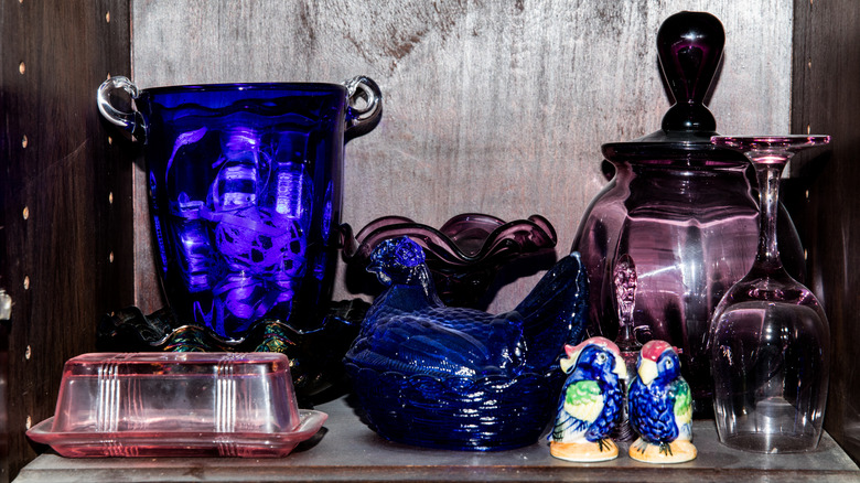 Kobalt mavisi ve ametist renkte renkli depresyon cam eşyalar bir Çin kabinesinde sergileniyor.