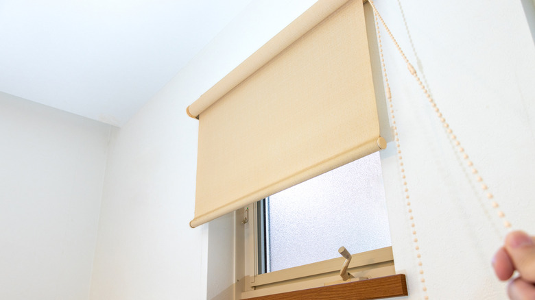 Garaj penceresinde bir gölgeyi aşağı çeken kişi