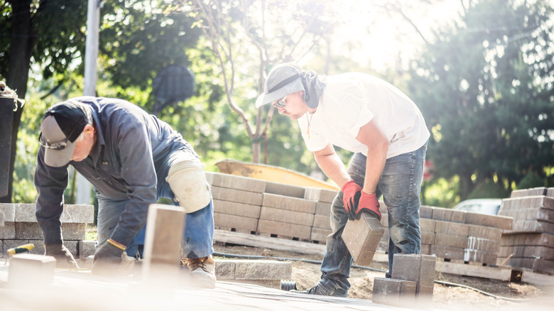 Bir baba ve oğul, kaldırım taşları bir araya getirin