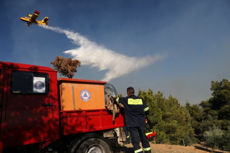 Atina'nın doğusundaki Pikermi banliyösünün yakınında bir orman yangını içerme çabaları sırasında itfaiye uçağı bir itfaiye üzerinden uçar. 03 Temmuz 2025.
