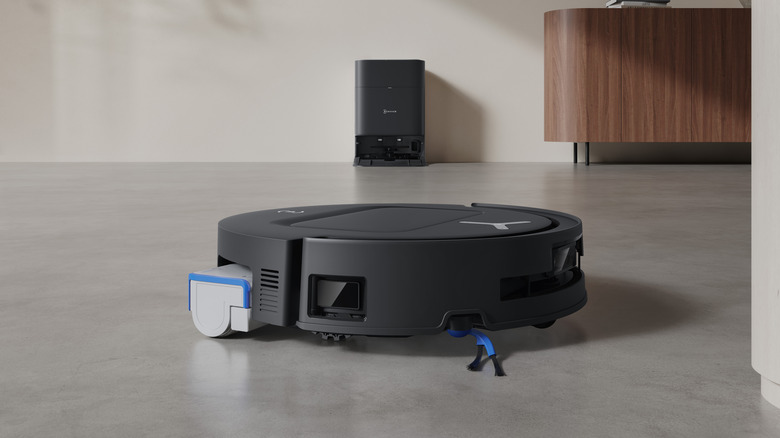 Arka planda bir yerleştirme istasyonu olan bir ECOVACS zemin temizleyici