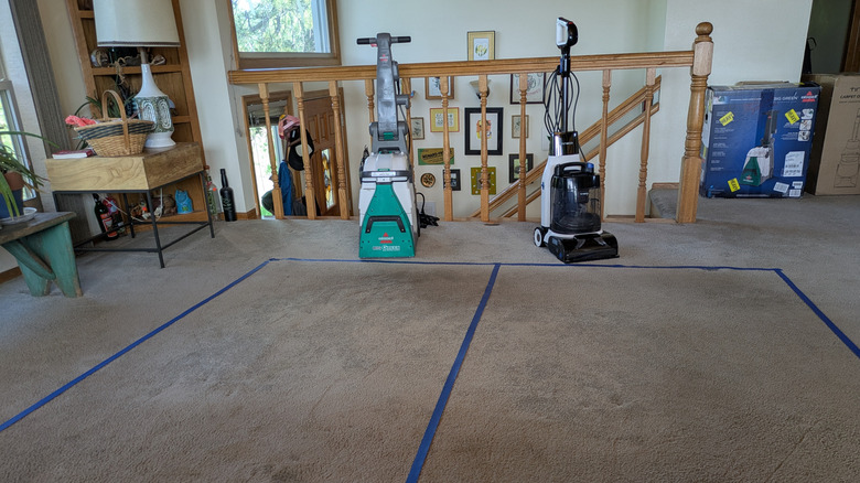 Bissell Big Green ve Tineco Halı Bir kruvazör, test halı yamalarının yanında duruyor.