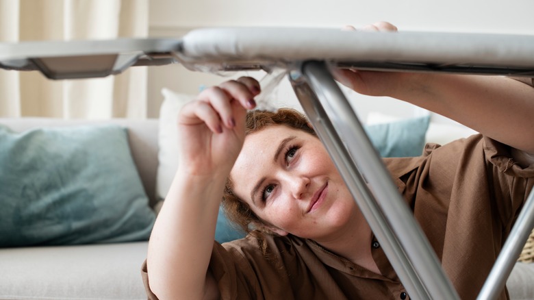 Bir ütü kurma tahtası kuran bir kadın